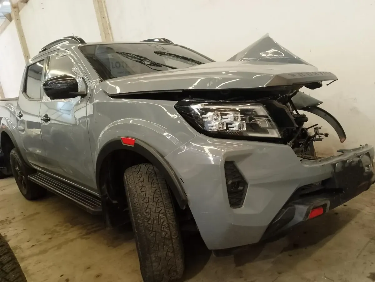 Nissan Frontier cinza com capô aberto em desmonte